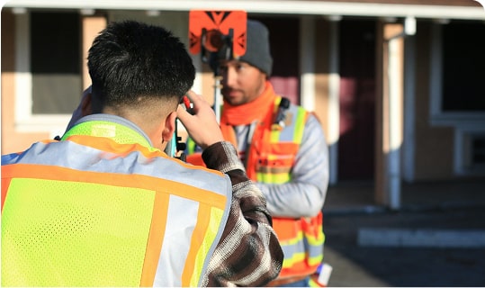 Des gémoètres-experts réalisent des relevés sur un terrain